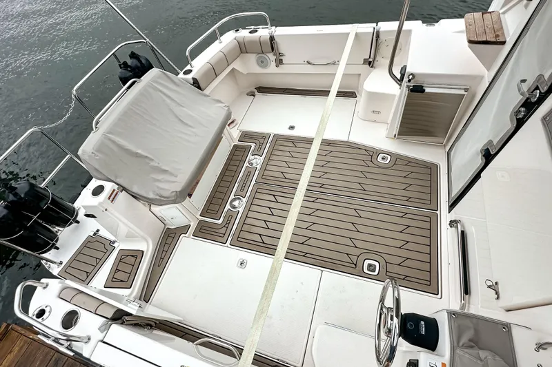 Slide: The Image of 2022 Cutwater 30 Command Bridge boat deck with seating and covered helm, docked by water. - 58
