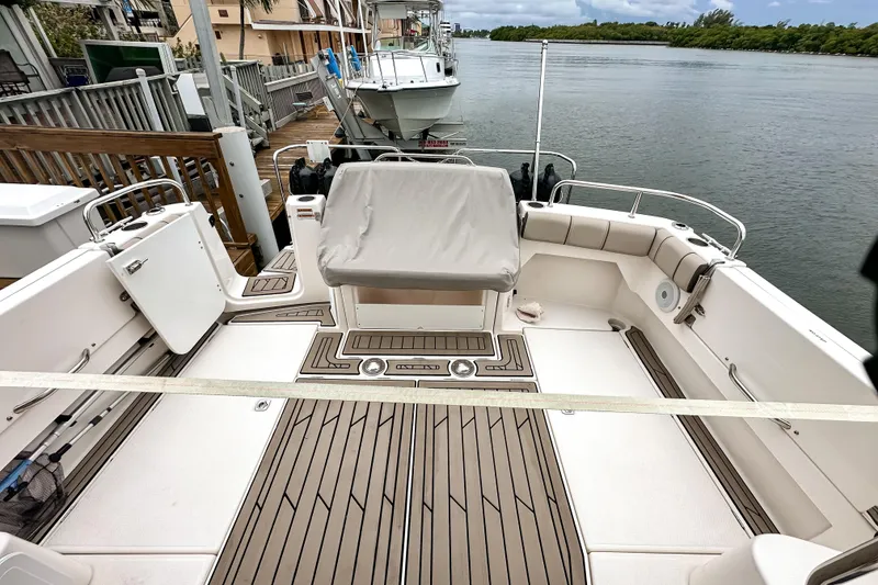 Slide: The Image of 2022 Cutwater 30 Command Bridge boat with spacious deck and seating, docked by the water. - 7