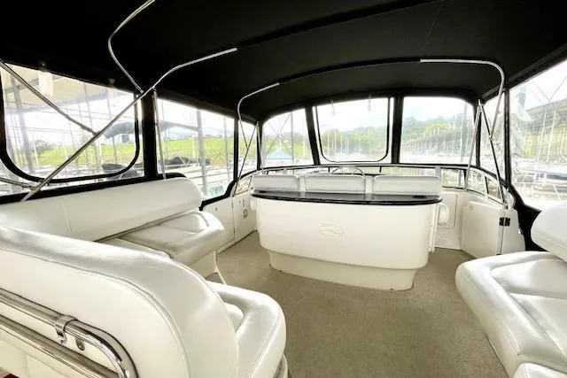 Slide: The Image of Interior of 2002 Silverton 43 Motor Yacht with white seating and panoramic windows. - 12