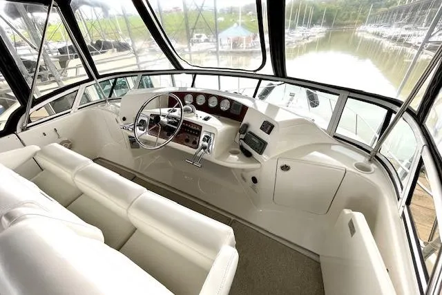 Slide: The Image of Interior helm of 2002 Silverton 43 Motor Yacht with white seating and control panel. - 16