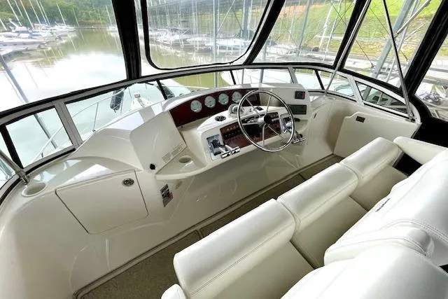 Slide: The Image of 2002 Silverton 43 Motor Yacht helm with white seating and panoramic windows. - 17