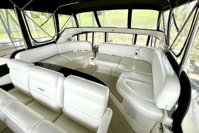 Slide: The Image of 2002 Silverton 43 Motor Yacht interior with white leather seating and panoramic windows. - 18