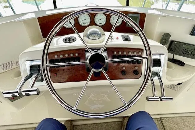 Slide: The Image of 2002 Silverton 43 Motor Yacht helm with steering wheel and control panel. - 21