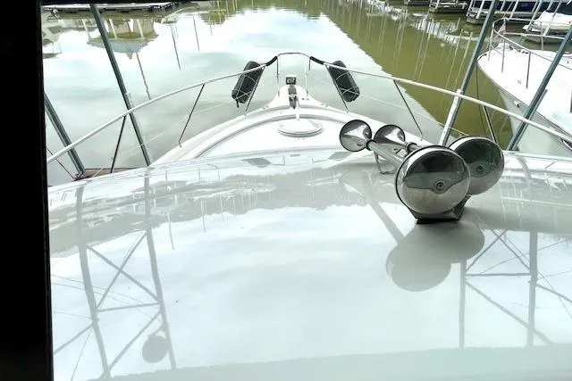 Slide: The Image of 2002 Silverton 43 Motor Yacht bow view at marina, reflecting water and docked boats. - 24