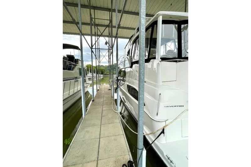 Slide: The Image of 2002 Silverton 43 Motor Yacht docked under a covered marina. - 3