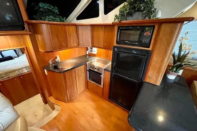 Slide: The Image of Luxurious kitchen interior of 2002 Silverton 43 Motor Yacht with modern appliances and wood cabinetry. - 34
