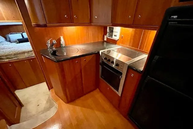 Slide: The Image of 2002 Silverton 43 Motor Yacht kitchen with wood cabinetry and modern appliances. - 38