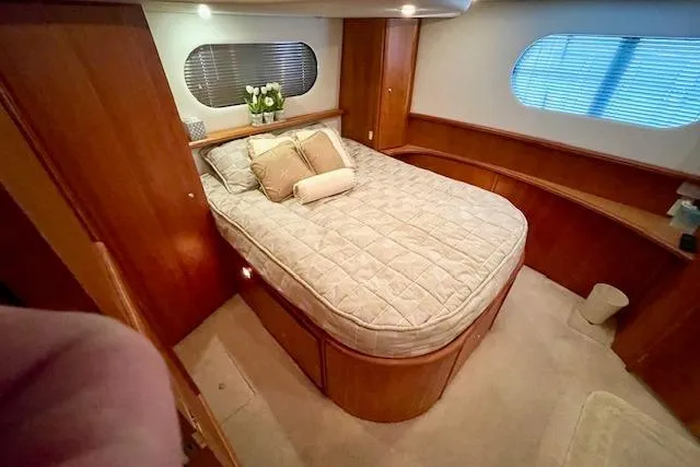 Slide: The Image of Luxurious bedroom interior of 2002 Silverton 43 Motor Yacht with cozy bed and elegant wood finish. - 44