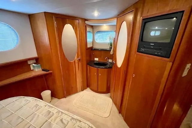 Slide: The Image of Interior of 2002 Silverton 43 Motor Yacht with wood paneling and built-in TV. - 46