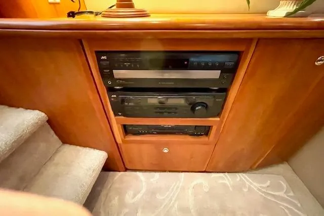 Slide: The Image of 2002 Silverton 43 Motor Yacht interior with built-in audio system and wooden cabinetry. - 52