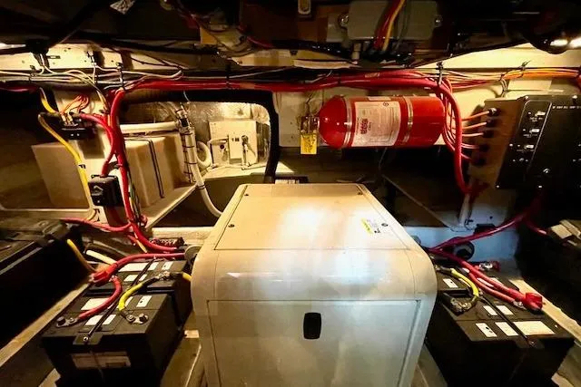 Slide: The Image of Engine room of a 2002 Silverton 43 Motor Yacht with batteries and fire extinguisher. - 54