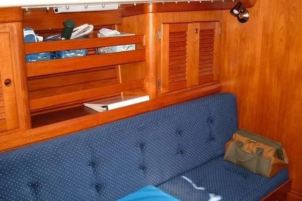 Slide: The Image of Interior of 1985 Bristol 31.1 Keel Center Board sailboat with wooden cabinetry and blue seating. - 3