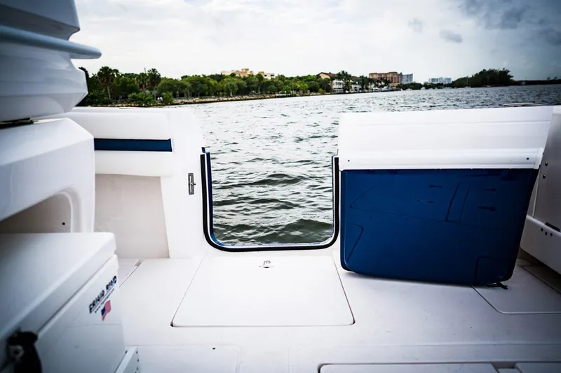 Slide: The Image of 2022 Intrepid 327-I CC boat interior with white seating and storage compartments. - 16