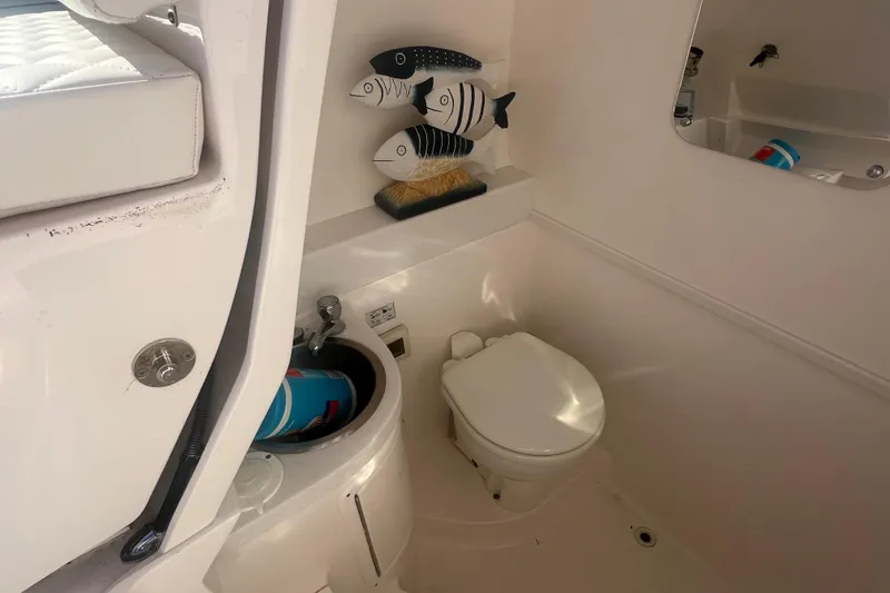 Slide: The Image of 2022 Intrepid 327-I CC boat bathroom with toilet, sink, and fish decor. - 21