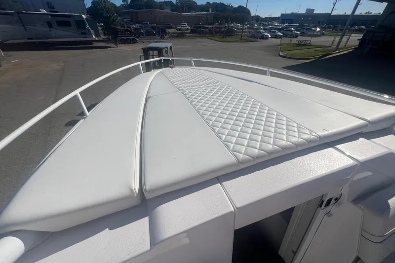 Slide: The Image of 2022 Intrepid 327-I CC boat with white cushioned deck, parked in a marina. - 26