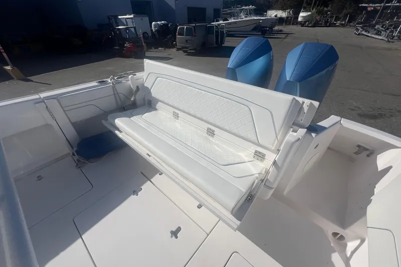 Slide: The Image of 2022 Intrepid 327-I CC boat with foldable white seating and dual blue outboard motors. - 39
