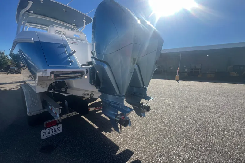 Slide: The Image of 2022 Intrepid 327-I CC boat with dual outboard motors on a trailer in sunlight. - 50