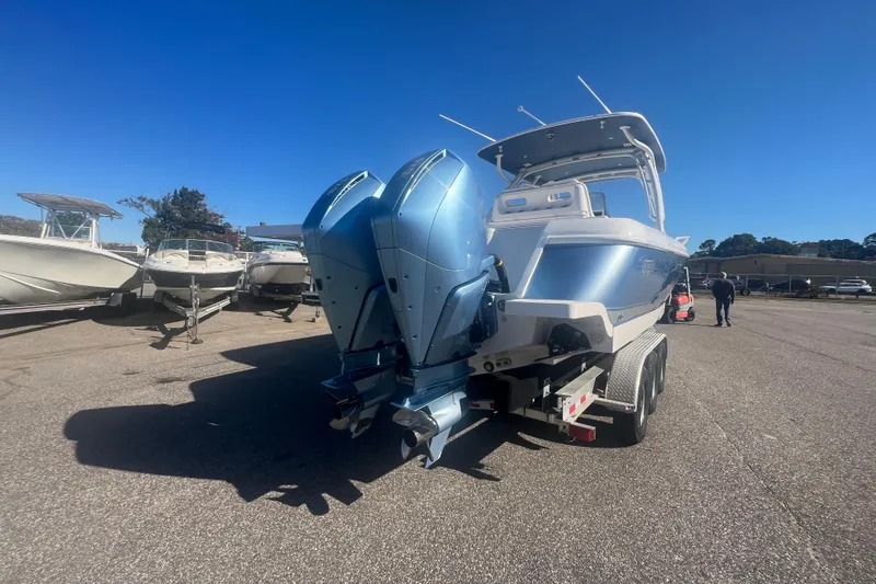 Slide: The Image of 2022 Intrepid 327-I CC boat with dual engines on a trailer, parked outdoors. - 51