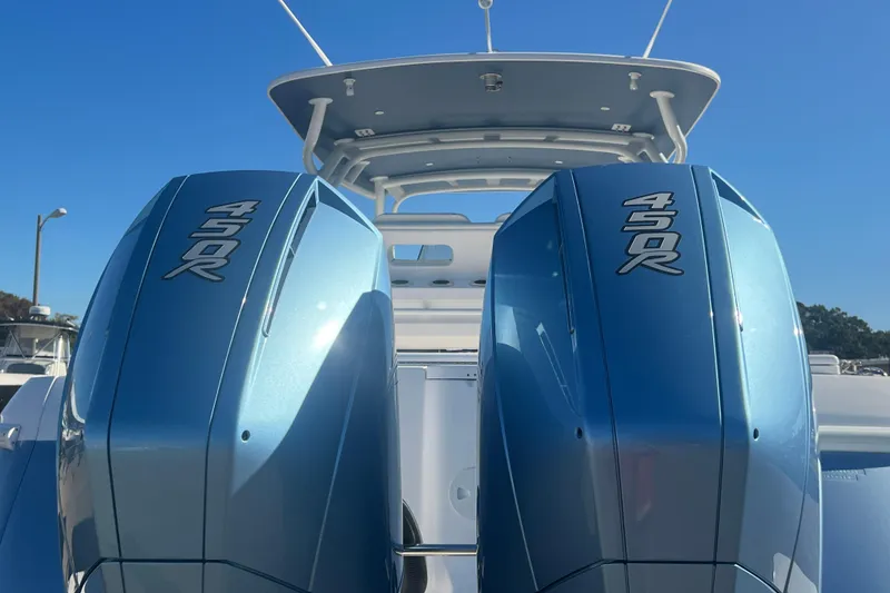 Slide: The Image of Twin 450R engines on a 2022 Intrepid 327-I CC boat under clear blue sky. - 52