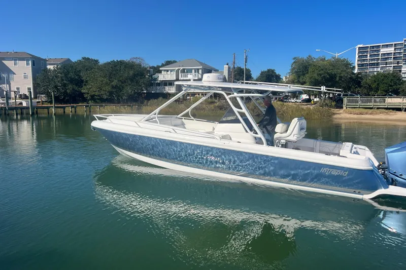 Slide: The Image of 2022 Intrepid 327-I CC boat on calm water near residential area. - 56