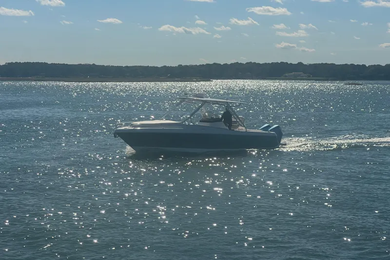 Slide: The Image of 2022 Intrepid 327-I CC boat cruising on sparkling water under a sunny sky. - 59