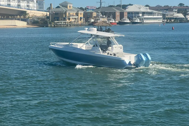 Slide: The Image of 2022 Intrepid 327-I CC boat cruising in a scenic waterfront area. - 62