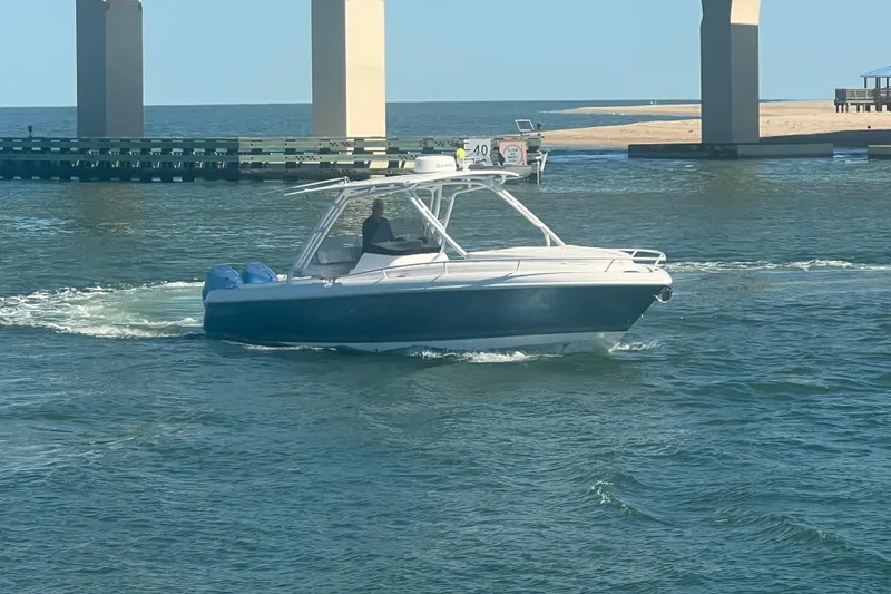 Slide: The Image of 2022 Intrepid 327-I CC boat cruising near bridge on sunny day. - 67
