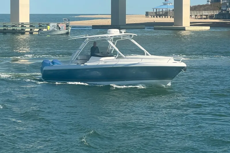 Slide: The Image of 2022 Intrepid 327-I CC boat cruising under a bridge on a sunny day. - 68