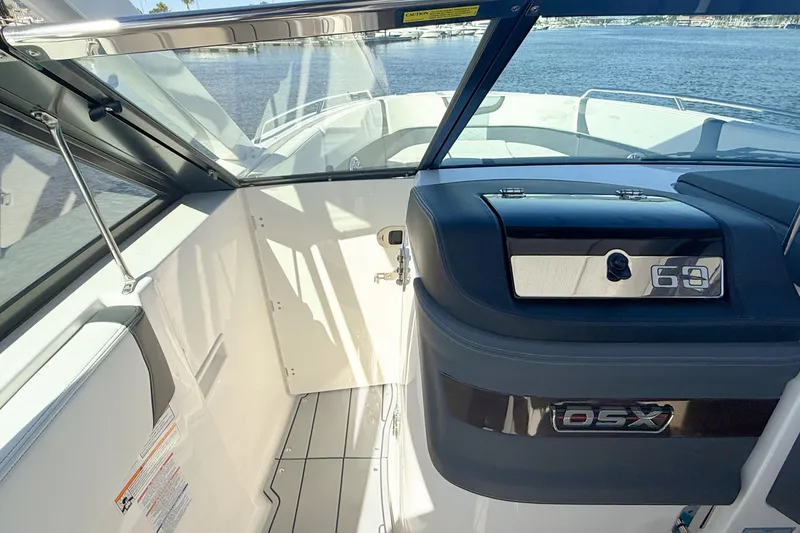 Slide: The Image of 2025 Chaparral 280 OSX boat with dual engines and American flag on water. - 16