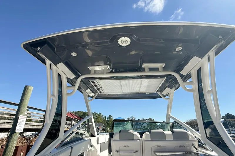 Slide: The Image of 2025 Chaparral 280 OSX boat cruising on a river, American flag waving. - 8