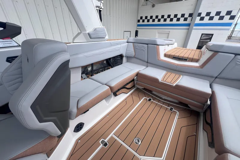 Slide: The Image of 2025 Nautique Super Air Nautique G23 interior with luxurious seating and teak flooring. - 13