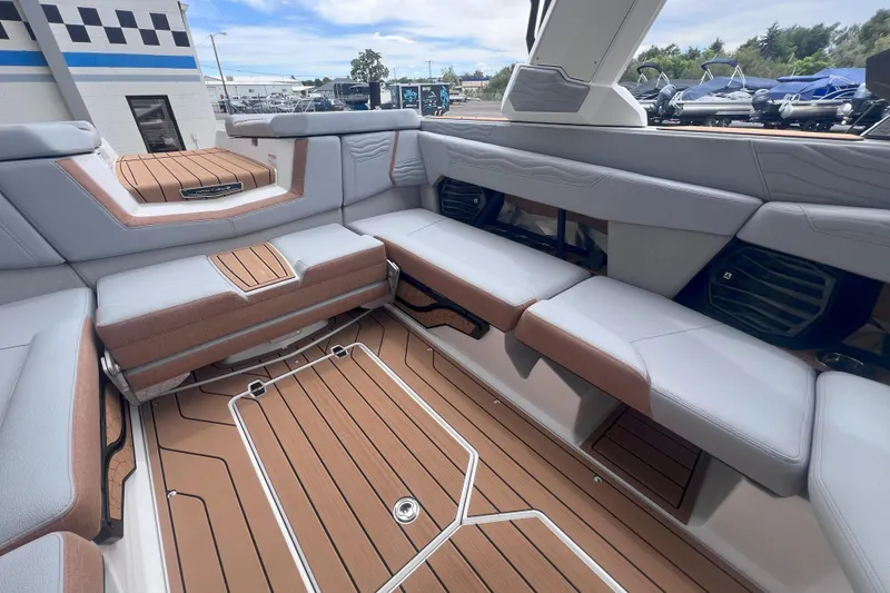 Slide: The Image of 2025 Nautique Super Air Nautique G23 interior with luxurious seating and teak flooring. - 14