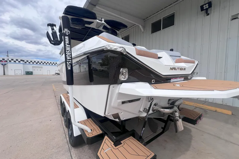 Slide: The Image of 2025 Nautique Super Air Nautique G23 boat, rear view, parked at a marina. - 3