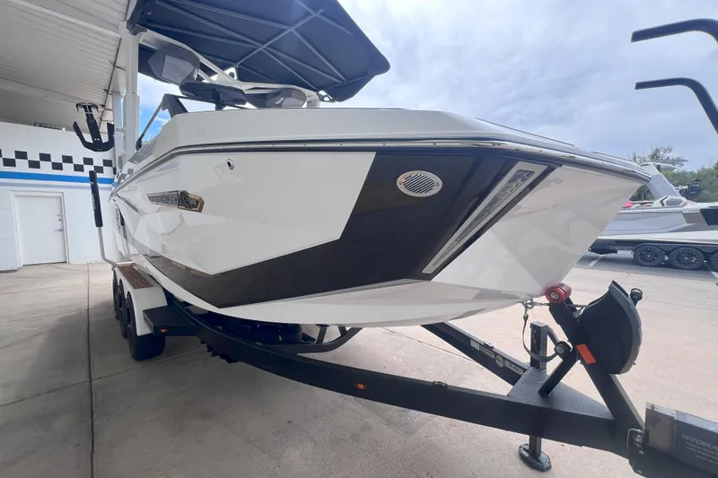 Slide: The Image of 2025 Nautique Super Air Nautique G23 boat on trailer, parked in a covered area. - 7