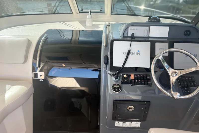 Slide: The Image of Helm of 2012 Pursuit OS 345 Offshore boat with Garmin navigation system and white captain's chair. - 10