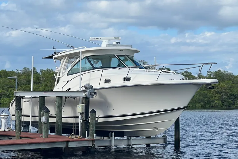 Slide: The Image of 2012 Pursuit OS 345 Offshore boat on calm water under clear blue sky. - 2