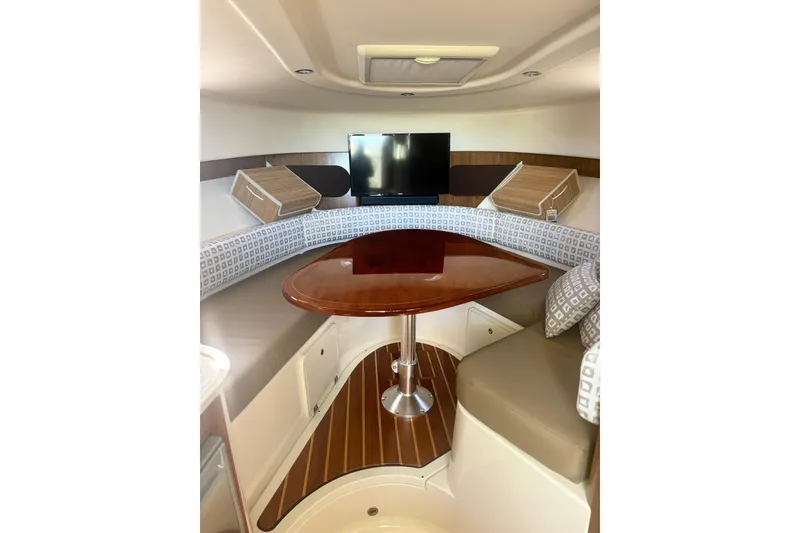 Slide: The Image of 2012 Pursuit OS 345 Offshore cabin interior with TV, table, and seating. - 21