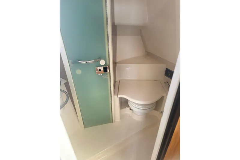 Slide: The Image of 2012 Pursuit OS 345 Offshore boat bathroom with compact toilet and modern design. - 24