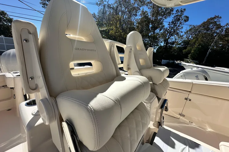 Slide: The Image of 2026 Grady-White Canyon 306 boat seats, luxurious white leather, outdoor setting. - 22