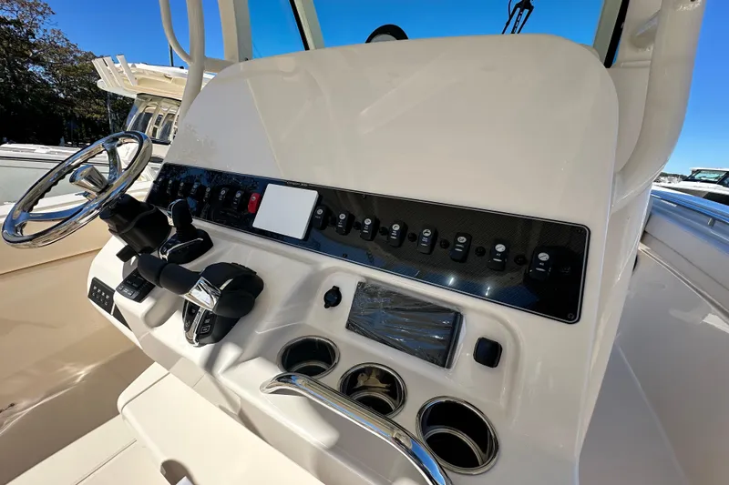 Slide: The Image of 2026 Grady-White Canyon 306 boat dashboard with steering wheel and control panel. - 23