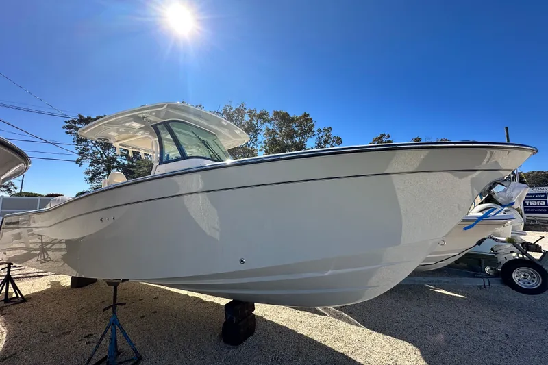 Slide: The Image of 2026 Grady-White Canyon 306 boat under bright sun, displayed outdoors. - 3