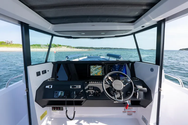 Slide: The Image of Open storage compartment on 2026 Axopar 29 XC Cross Cabin boat, with water in background. - 22