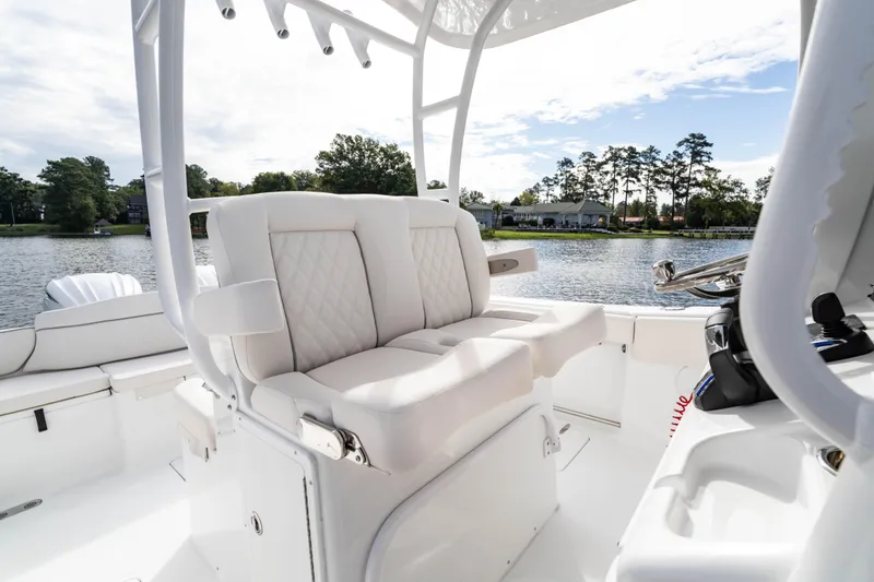 Slide: The Image of 2026 Sea Hunt Ultra 285 Coffin Box boat interior with white seating and water view. - 15