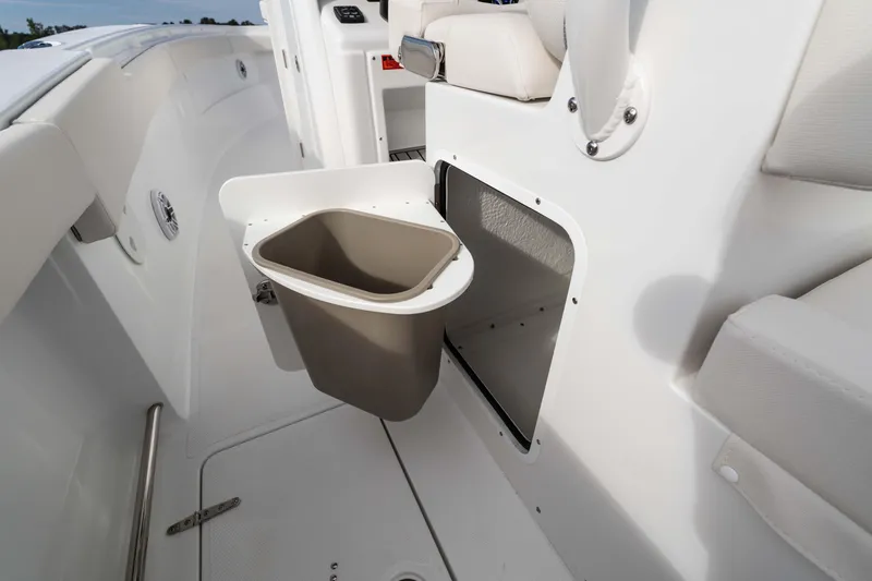 Slide: The Image of 2026 Sea Hunt Ultra 285 Coffin Box boat interior with storage compartment and trash bin. - 17