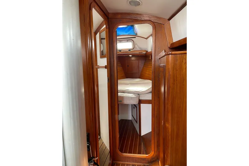 Slide: The Image of Interior of 1986 Victoria 34 Sloop, featuring wooden cabin and cozy sleeping area. - 12