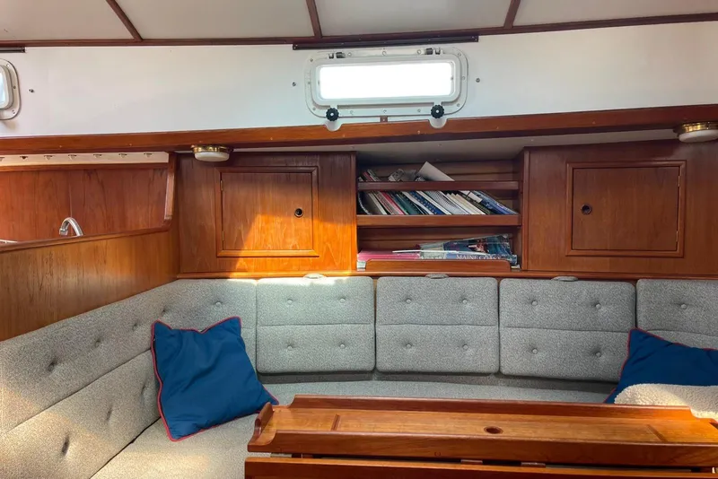Slide: The Image of Cozy interior of 1986 Victoria 34 Sloop with wooden cabinets and cushioned seating. - 2