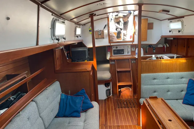 Slide: The Image of Interior of 1986 Victoria 34 Sloop sailboat with wooden furnishings and cozy seating. - 3