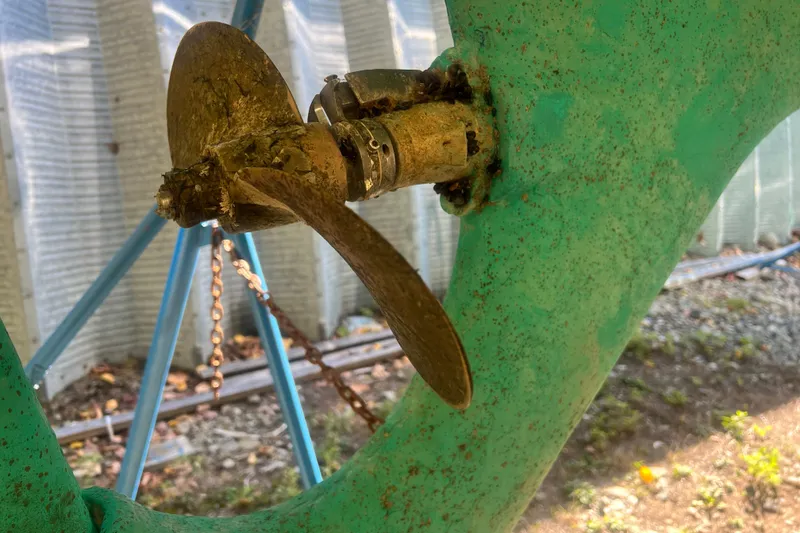 Slide: The Image of Close-up of a 1986 Victoria 34 Sloop propeller with green hull in dry dock. - 37