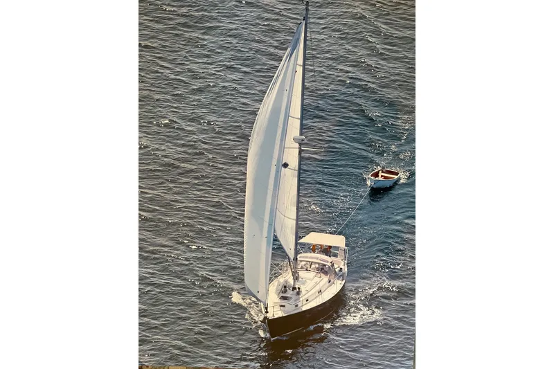 Slide: The Image of Aerial view of 1986 Victoria 34 Sloop sailing with a small dinghy in tow. - 53