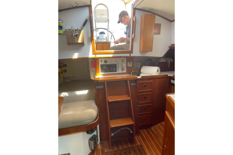 Slide: The Image of Interior of 1986 Victoria 34 Sloop with wooden cabinetry and seating area. - 8